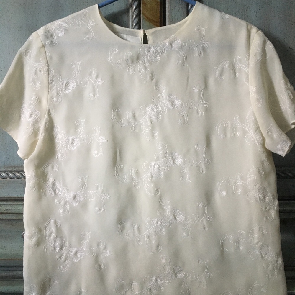 Cream colored short sleeve blouse with same color floral stitching design.